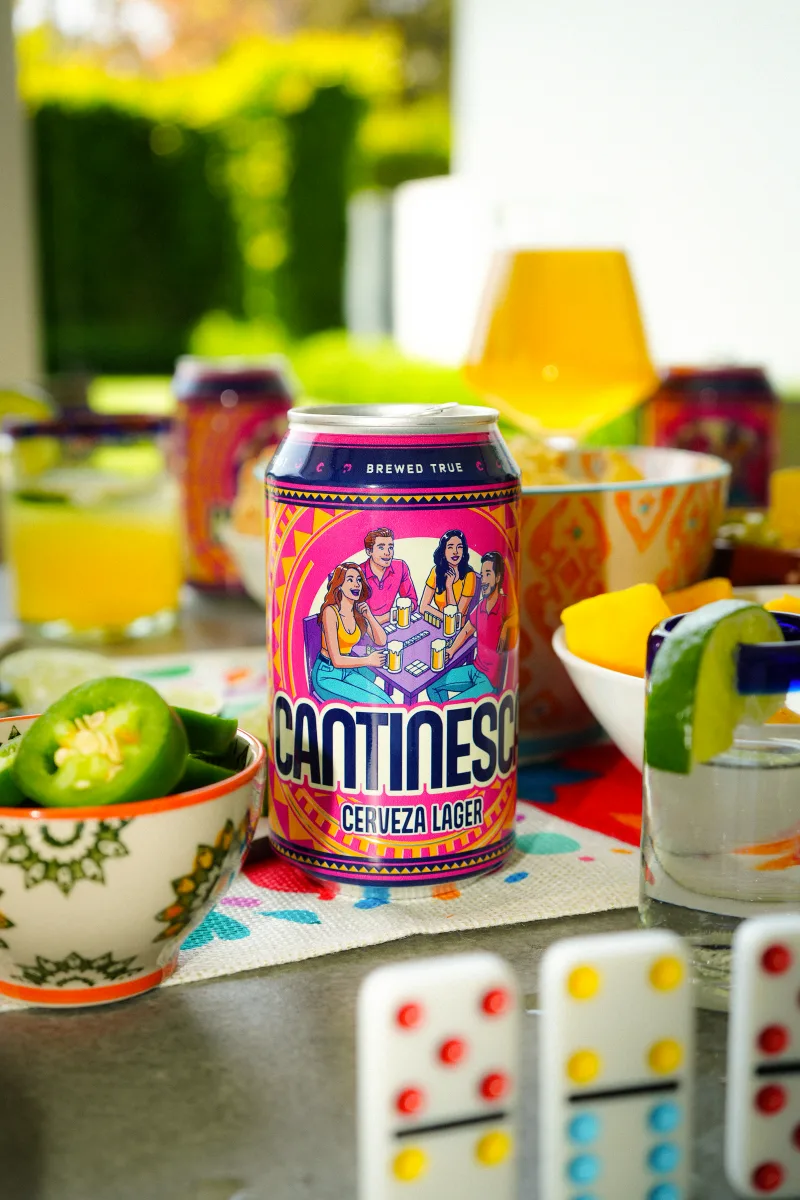 Cantinesca on a crowded table with citrus drinks and dominoes